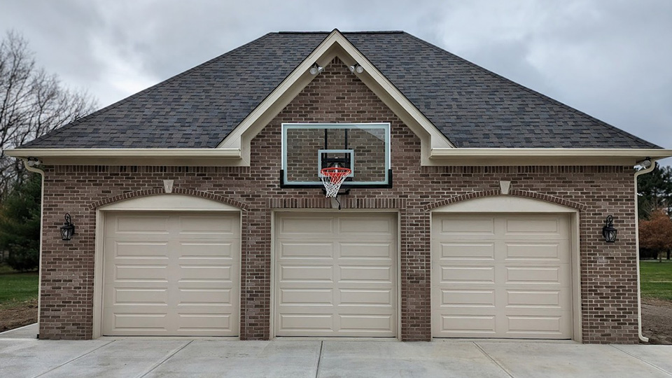 custom brick garage construction with three-car doors and attached residential design by Gannon and Company
