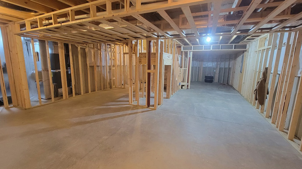 home addition framing in progress with exposed wood studs and open floor plan by Gannon and Company