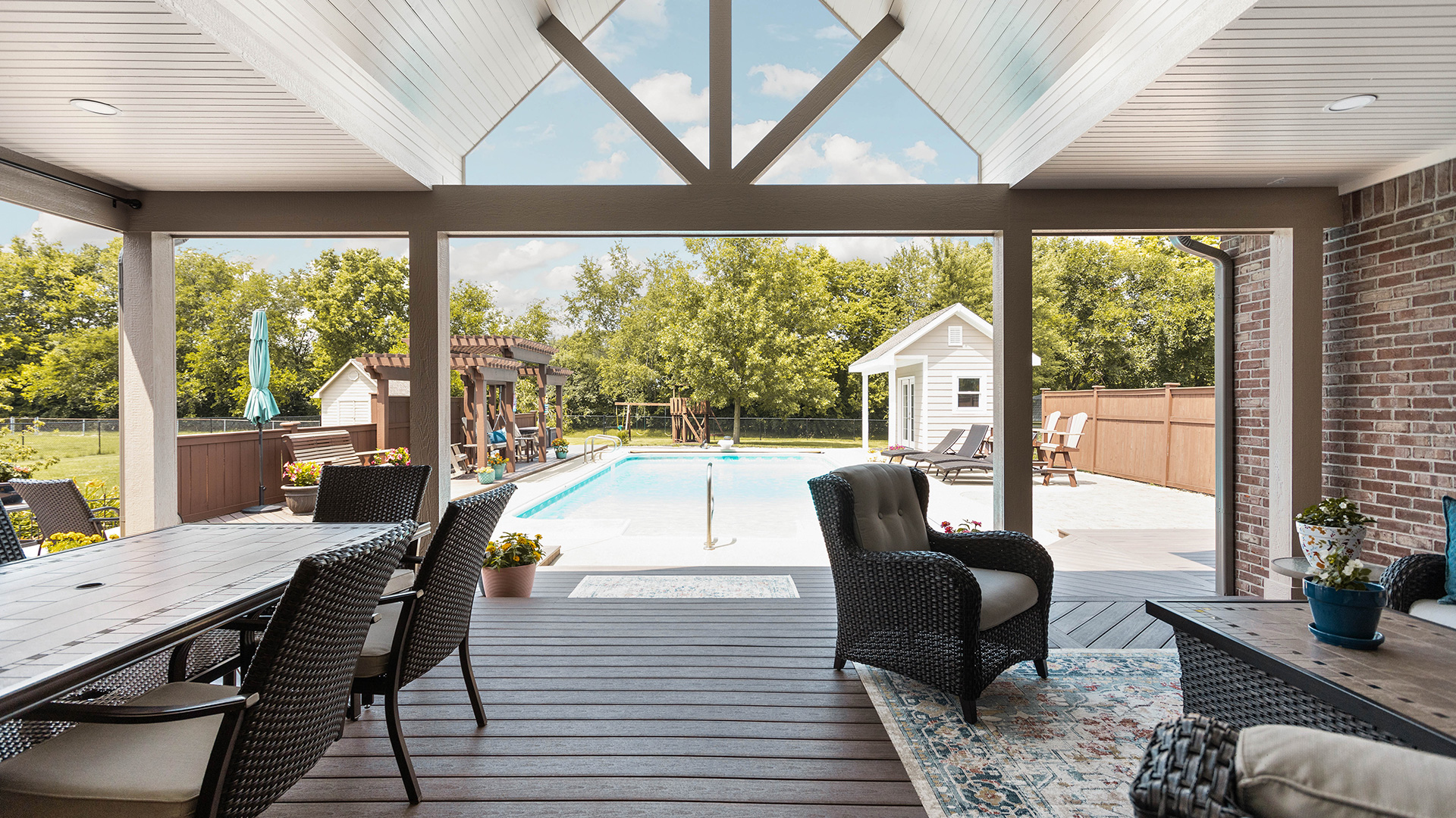 covered outdoor patio and deck with pool view and custom wood ceiling by Gannon and Company